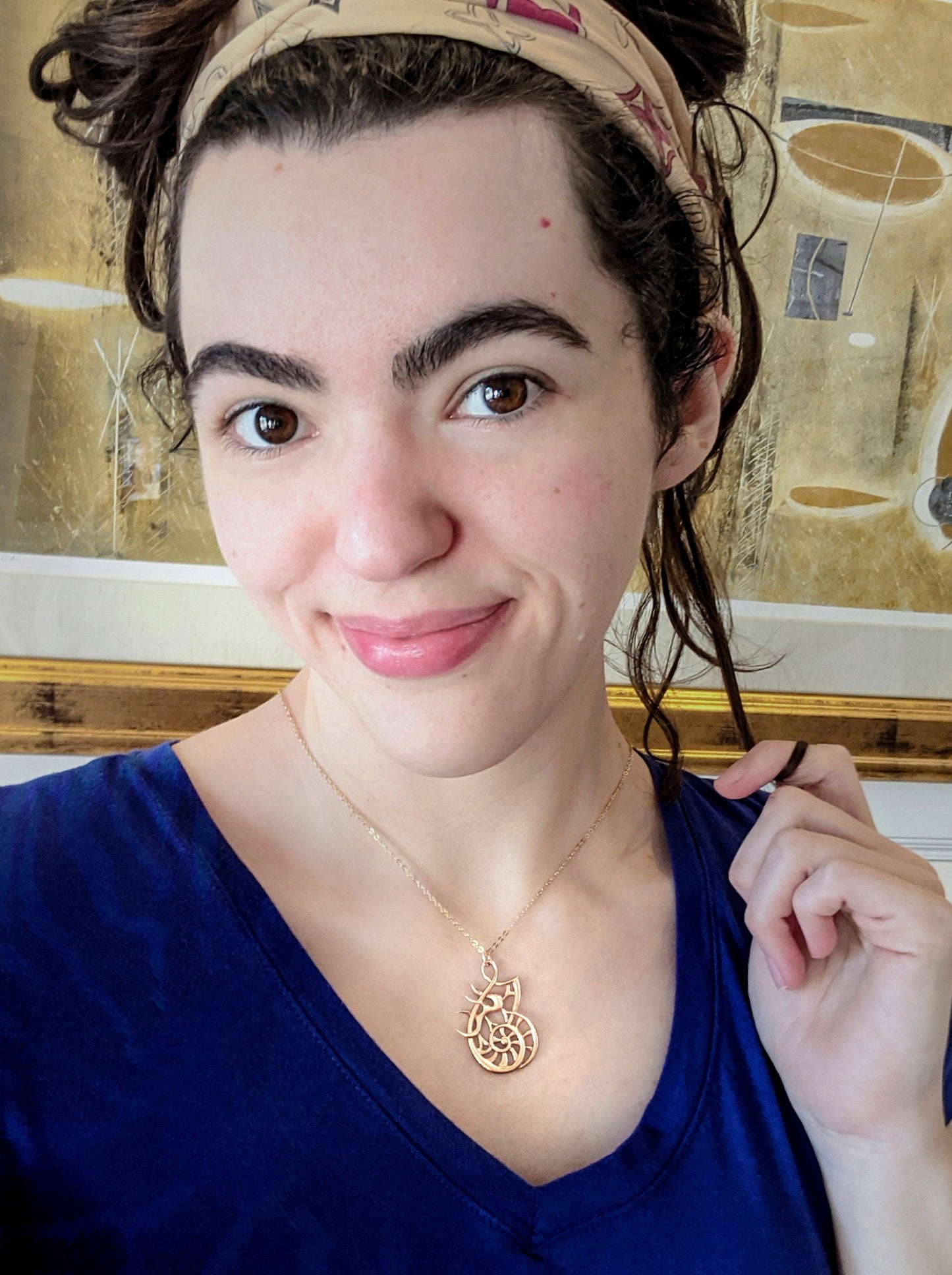 A female model wearing the Sea Chariot pendant.